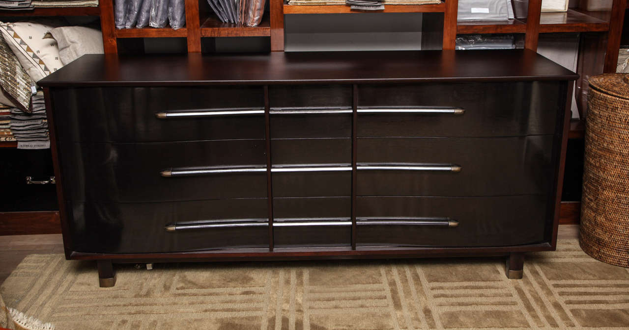 Henredon Heritage nine-drawer dresser; outside case is refinished in a satin, ebonized finish while the drawer fronts are highly polished; brass accents on wood drawer pulls circa 1940