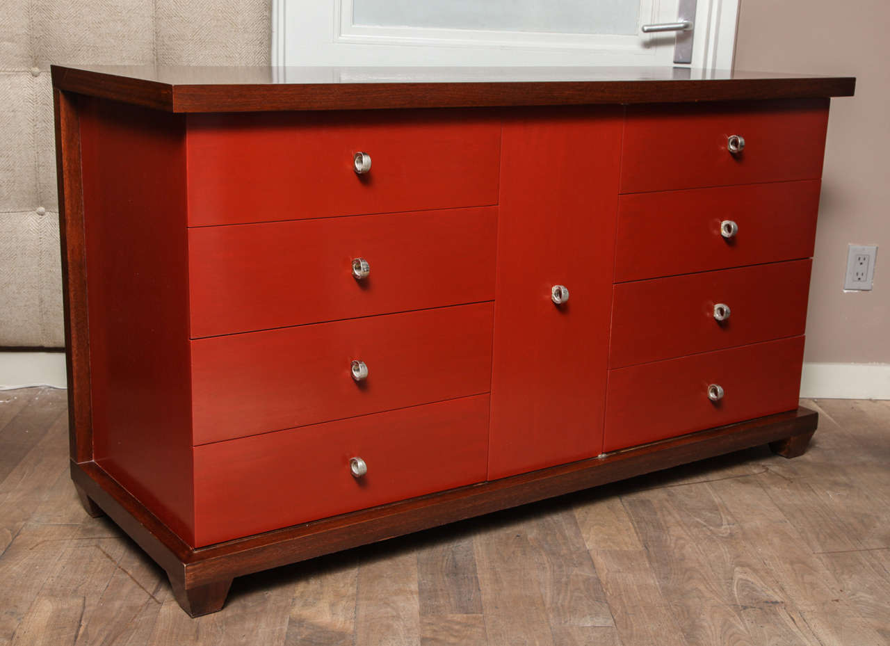 American of Martinsville walnut-finished dresser with cinnabar lacquered drawer fronts circa 1950 - ring pulls are brushed nickel; center cabinet with two concealed drawers flanked by eight large drawers