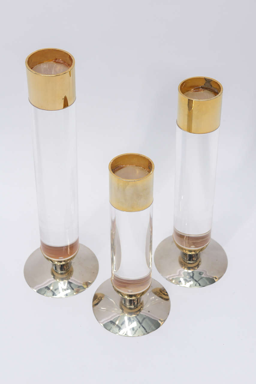 These gorgeous candle stands are made of Lucite with Brass bands on top and base who are sitting on a polished nickel base who have been chromed. They are heavy and beautifully made. They are supporting  2.4