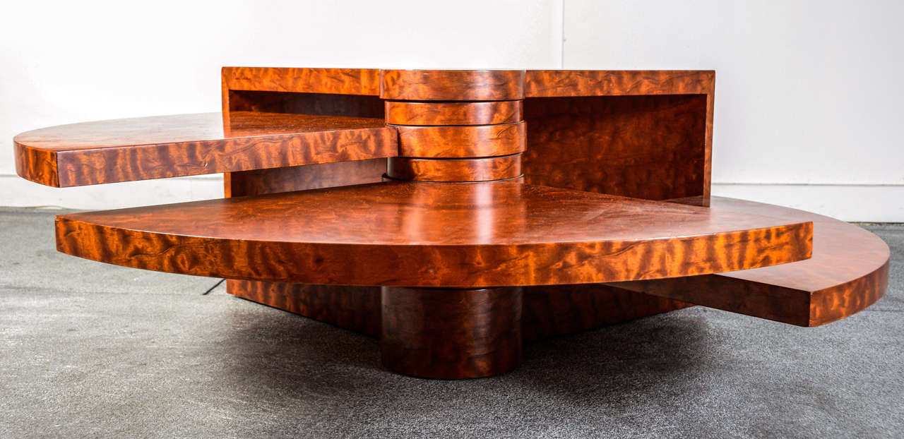 A wood coffee table by Pierre Cardin, signed and numbered of an edition of 20, circa 1970. The leaves of the table rotate on a central axis so to open and create a table of one's own invention.
