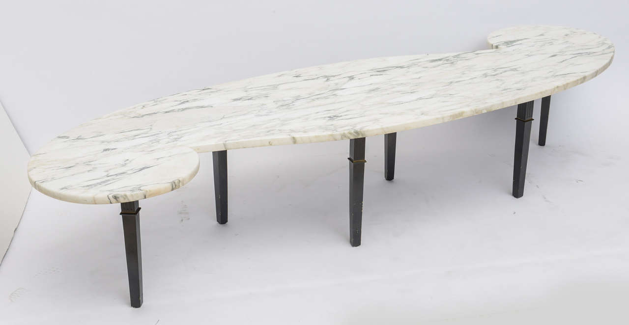 the cararra marble top in wave pattern above 6 patinated bronze square tapering legs
