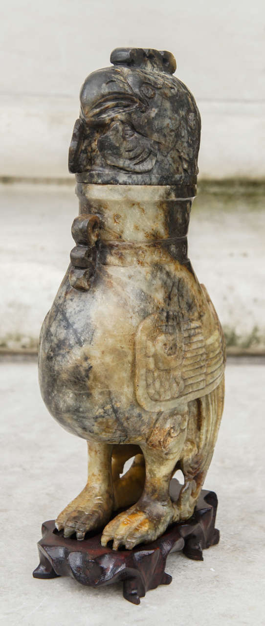 This vessel formed from carved variegated jade is in the form of an Archaistic bronze vase from China's ancient past. Carved in the 20th century most probably for export before the second world war the piece is a good example of the culture's