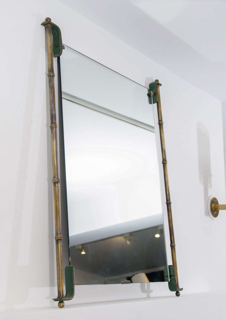 Brass bamboo framed mirror with leather details by Jacques Adnet.