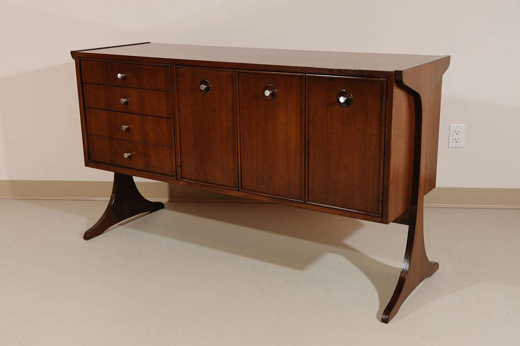 Very interesting 4 drawer, 2 door walnut cabinet/sideboard. Unusaual construction on 2 legs. Cabinet can be used as a room divider. Beautiful wood on the back of the cabinet. 1 half depth shelf inside.