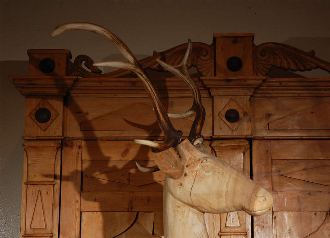 Large wood carved standing deer with real horns attached.