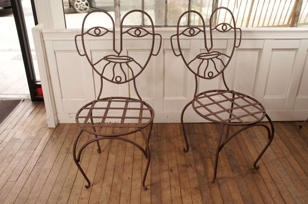 pair wrought iron whimsies - lattice seat - rests on stylized cabriole legs - sporting a picasso like face of a bearded man - found on cape cod, mass - 

seat height:  18 1/4
