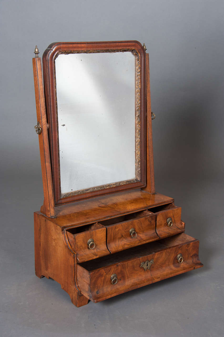 A fine Queen Anne period waterfall front walnut toilet mirror with four drawers, three over one.