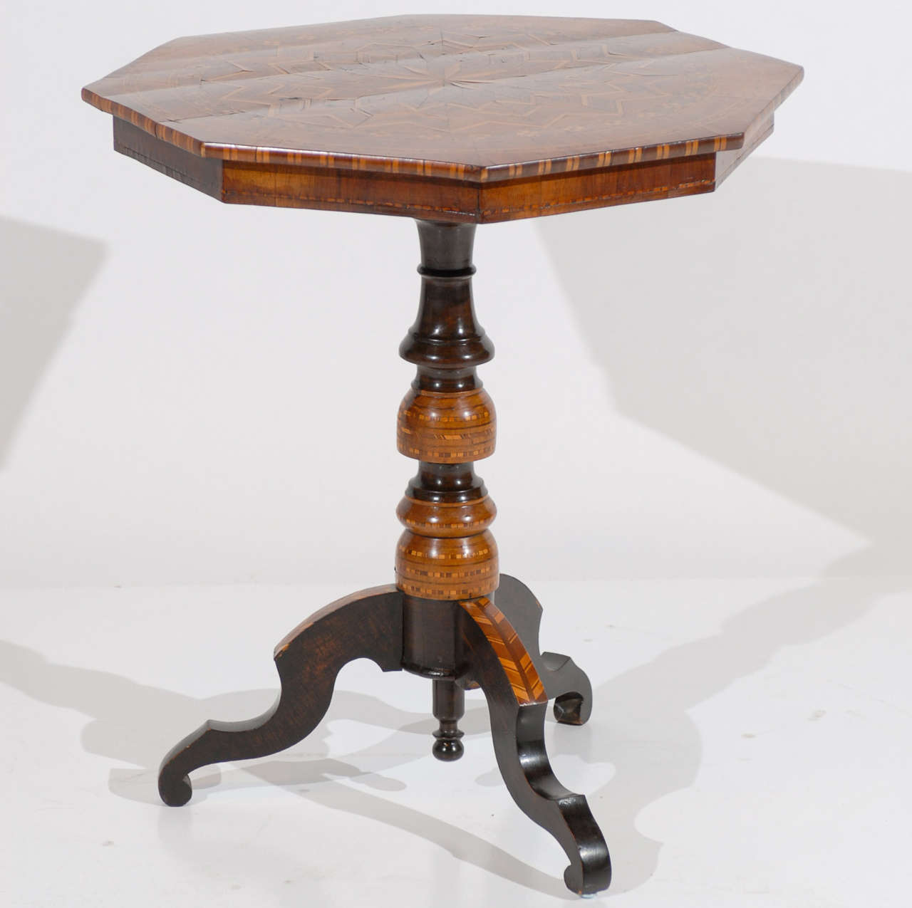 19th century walnut Sorrento table with octagonal shaped top, turned pedestal base, and shaped tripod legs. Walnut parquetry inlaid top with ebonized and parquetry inlay below. Some minor warping to the top. For many more fine antiques, please visit
