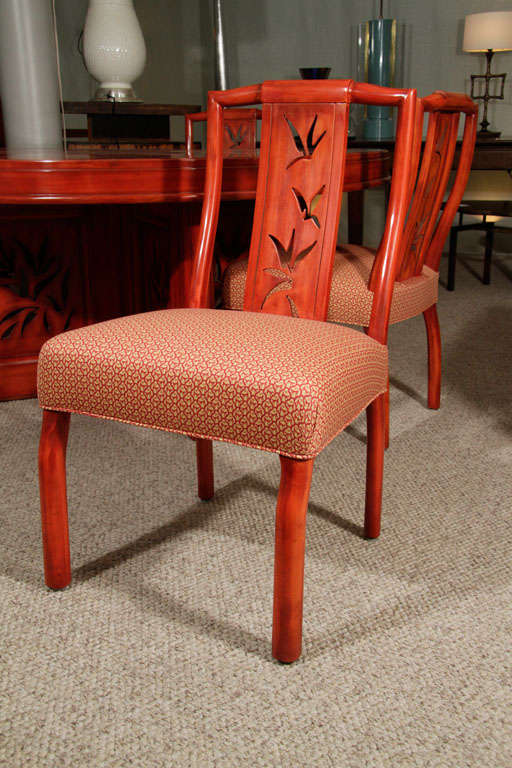 Original flame-red lacquer finish with Asian-inspired, carved backs. Four of the eight chairs have been re-upholstered. James Mont fabric labels on underside of most chairs.