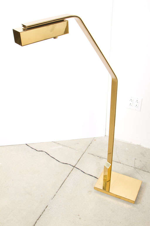 A substantial halogen reading lamp with dimmer control. The rectangular box shade is attached to a double flat bar stem and together pivots on a rectangular weighted base. The shade and stem assembly rotate nearly 360 degrees. A cylindrical knob