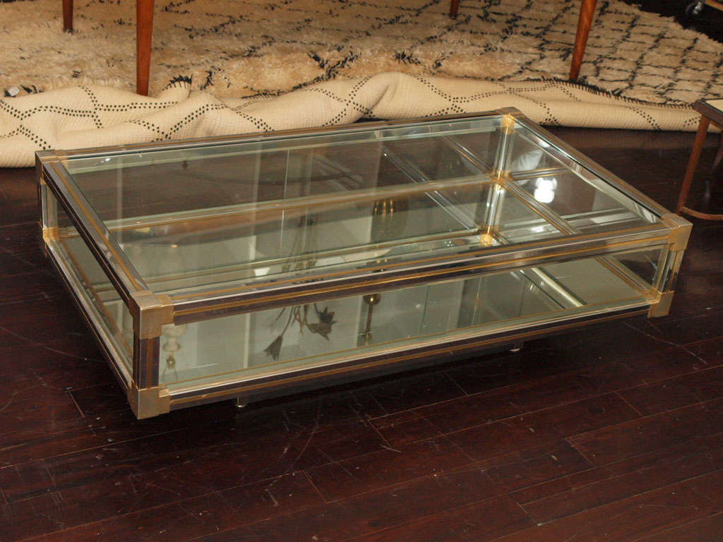 Rectangular coffee table in chrome and brass with mirrored bottom shelf; sliding glass panels at either long side allow access to central compartment