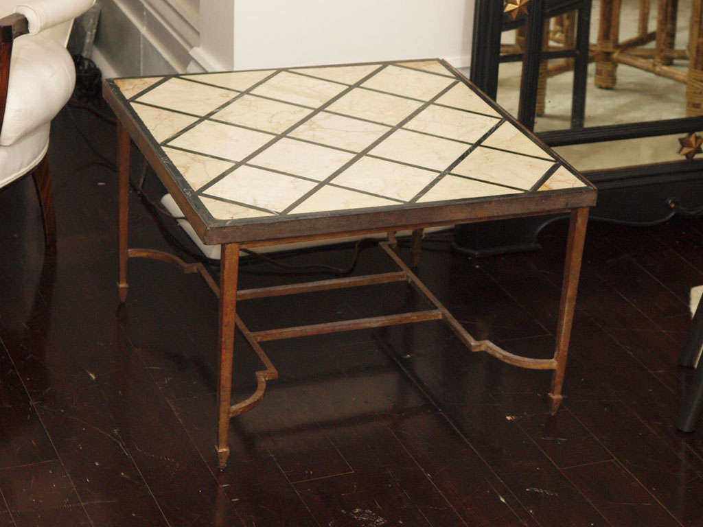 Square side table in gilt iron; interesting shaped stretchers; toupie feet; the plateau in lozenge-patterned in-laid stone