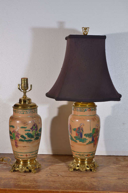 Asian, hand painted, electrified Oil Lamps, mounted on Original ornate brass bases. Lamps have Oriental Signature in the painting.  Shown with Black Silk, square bell lamp shade.  Shade not included in price of lamps.  Shade $125.00