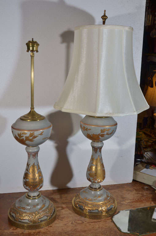 Exquisite, light blue/gray porcelain with gold leaf painted ornamentation over the blue/grey porcelain.  Originally oil lamps but have been mounted on a custom made light antiqued brass base.  Electrified with two pull chain sockets.  Priced without