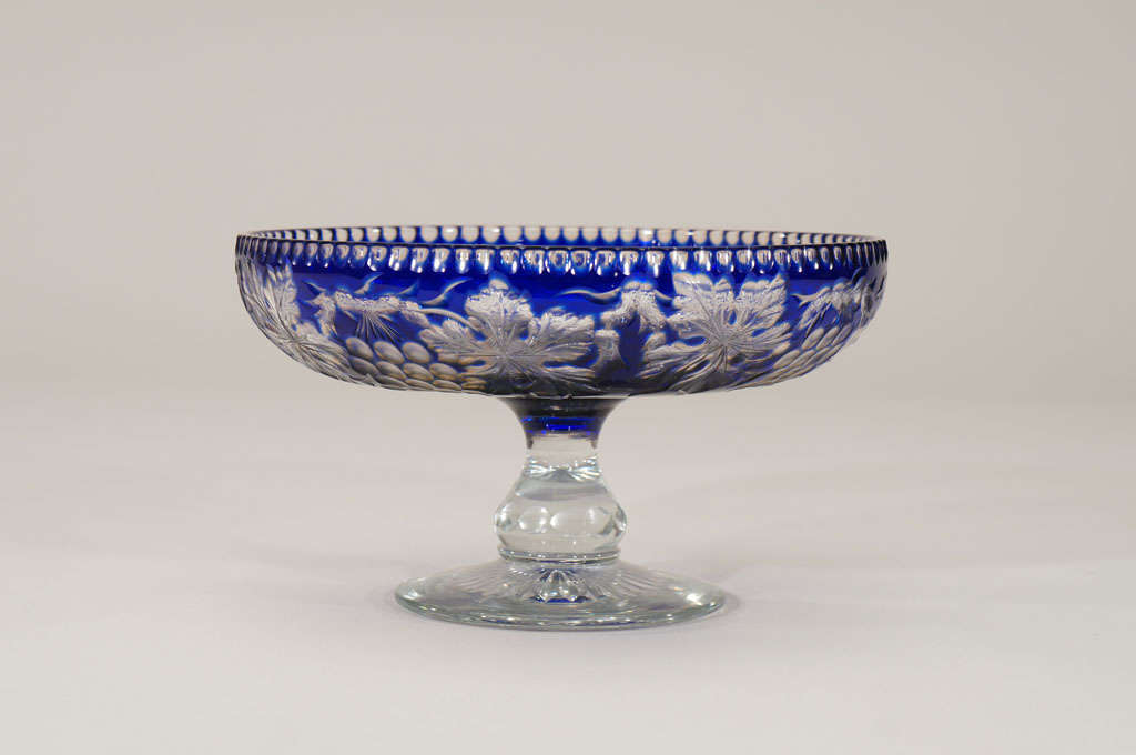 This rare example of Stevens and Williams overlay cut to clear has the additional layer of color. The cobalt layer is over a subtle amber over clear crystal, copper wheel engraved to reveal the trailing grapes and leaves of the 