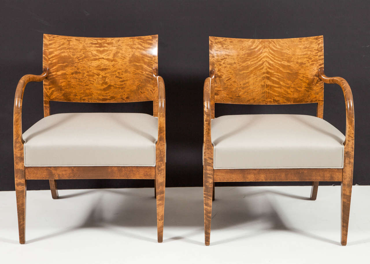 A pair of open armchairs, first designed and made by cabinetmaker Jørgen Christensen, Denmark, circa. 1928. 
Figured birchwood with full scrolled armrests and upholstered seats raised on square tapered legs.

 Literature – Danske Mobelkunst