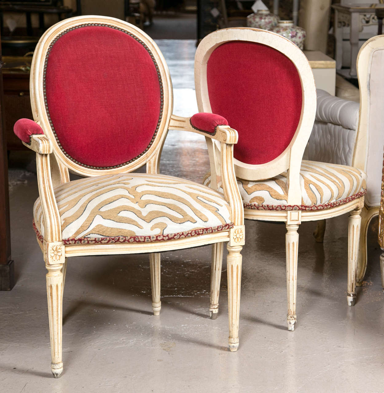 Set of eight Hollywood Regency style French dining chairs. These eight chairs are truly unique accentuating the albino zebra print on the seat and the red upholstery on the top of the back rests and arm rests adds an exciting contract to these Louis