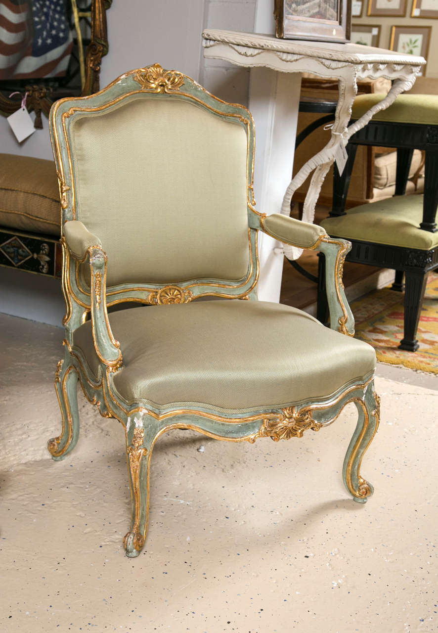 A fine pair of 19th century Louis XVI style parcel-gilt and paint decorated armchairs. Wonderfully gilded and upholstered in a warm neutral fabric palette emphasizing the exquisite nature of the design. The seat width is fantastic and roomy. The