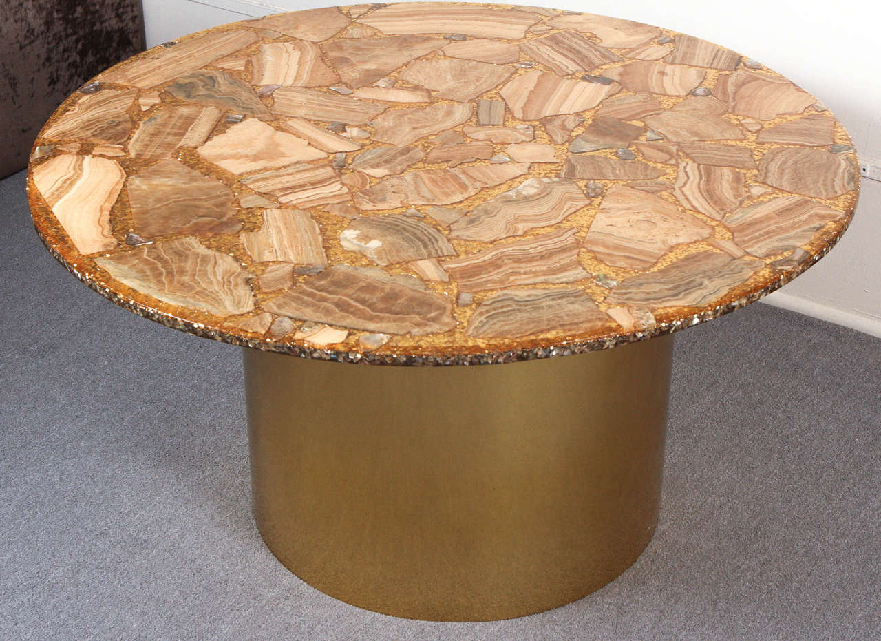 Fabulous circular coffee table. The top is a solid slab of resin with beautiful large pieces of agate and a few smaller abalone pieces embedded under the smooth surface. The spaces between the pieces of stone and shells are filled with brilliant