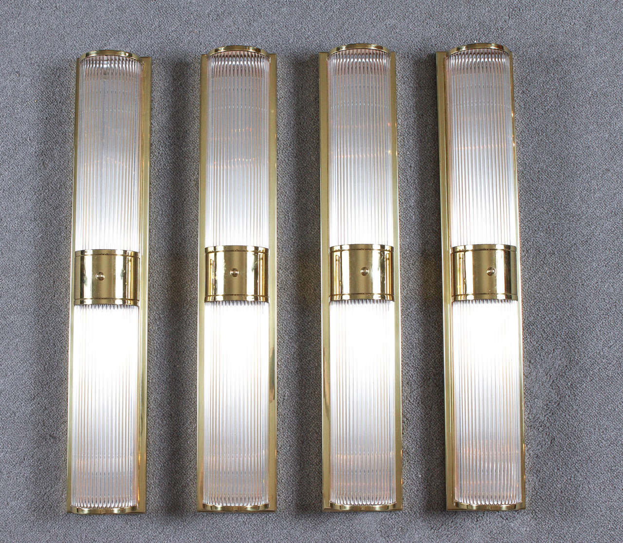1970s elegant brass and glass rod sconces by Gaetano Sciolari.
The polished brass frames hold thin glass rod tubes through which the light shines beautifully. They are priced by the pair.
(Two Pairs Available).