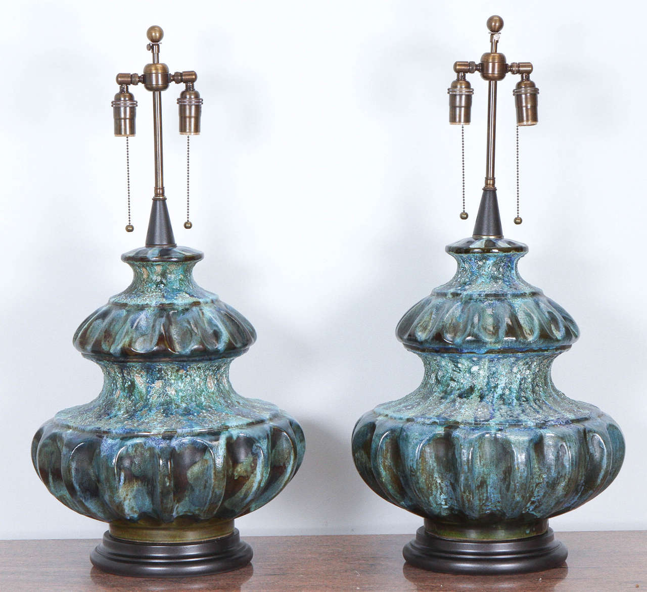 Spectacular pair of large ceramic lamps with a beautiful multicolored volcanic glaze. They lamps are newly rewired with antique bronze double clusters.