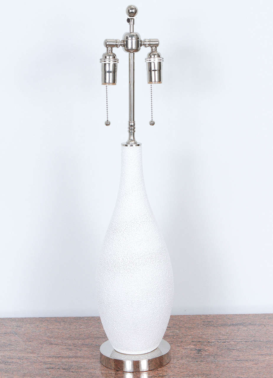 Pair of white ceramic table lamps.  The glaze is textured and resembles an all-over pattern of droplets.
The lamps are newly rewired and have nickel hardware with double clusters.