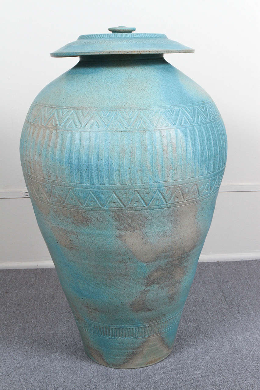 Truly monumental Amphora style ceramic vessel with a separate lid.
This piece is from an Indian Wells estate completely styled by Steve Chase and was custom ordered for Mr. Chase. It has a mottled verdigris matte glaze and shallow incised designs