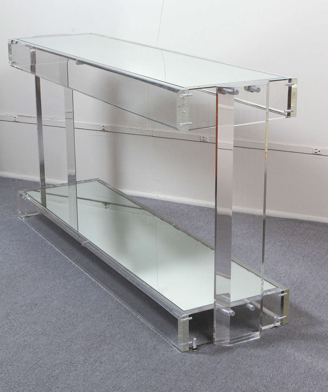 Elegant lucite console  with a mirrored top and bottom shelf inset in the lucite frame.