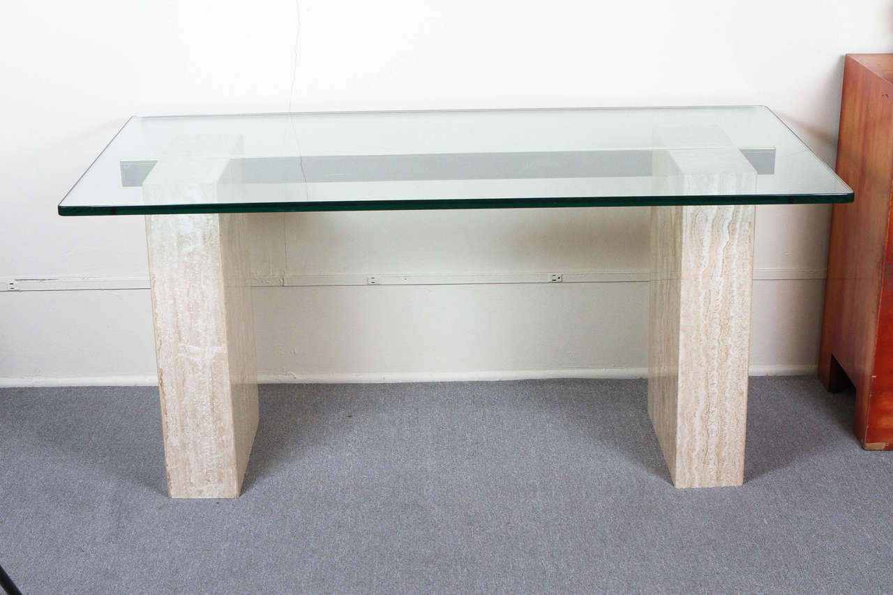 Large travertine and glass console or dining table. 
There is a polished brass bar connecting the two rectangular travertine pillars which supports the 3/4 glass top
The scale of the top would allow this piece to be used as a dining table
There