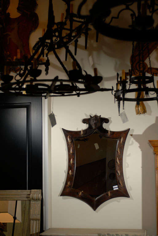 A Black Forest Style Belgian mirror with carved boar's head at the crest and mounted tusks on the frame, 20th century.