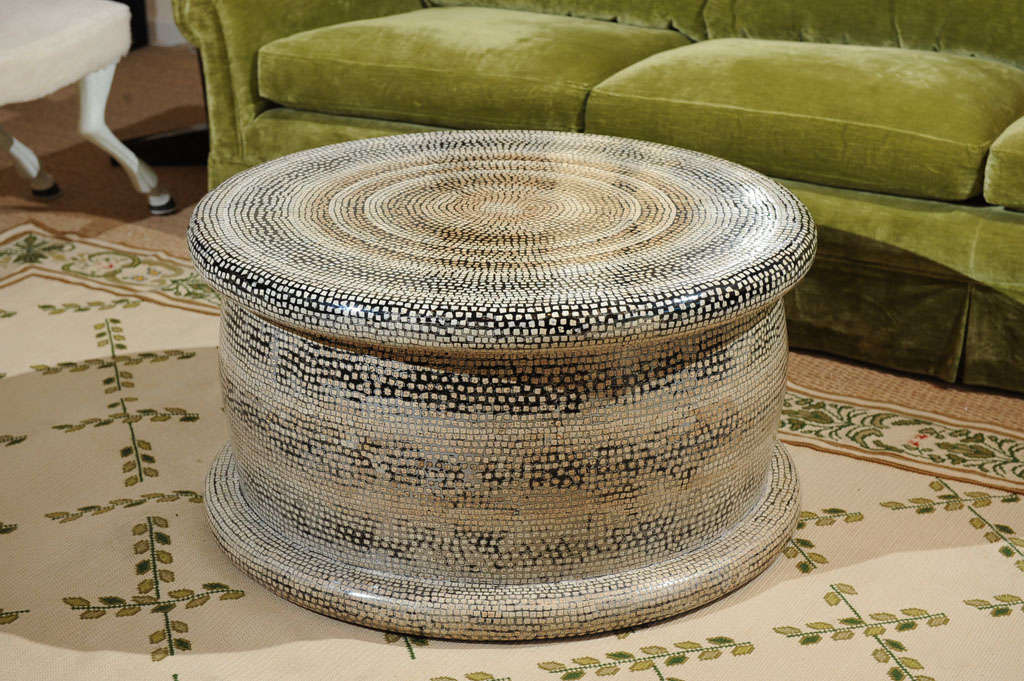 An Italian style circular coffee table with a mosaic inlay of colored eggshells and a high lacquer finish