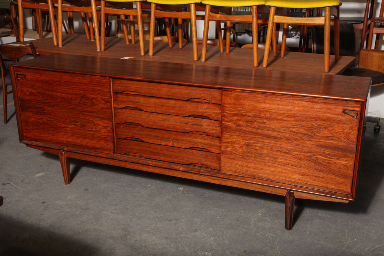 Vintage 1960s Danish Credenza in Rosewood.

This Vintage Cabinet is amazing in it's very simple form. This cabinet has the most basic and useful with it's adjustable shelving on either side that is accessible sliding door, and it's middle section