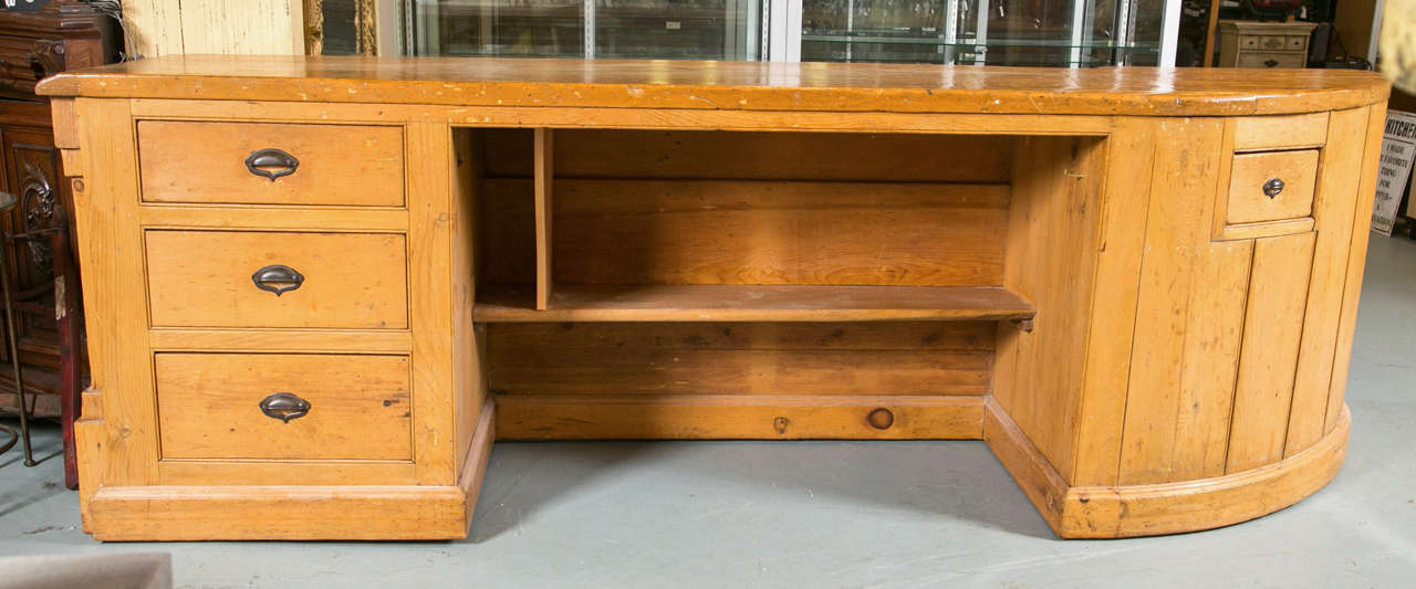 Antique pine general store counter with drawers and nook underneath.  This fantastic piece is hand made of solid pine and shaped with a curve at one end .
Great size for use in store, kitchen or counter project. Recessed panels on front and sides.