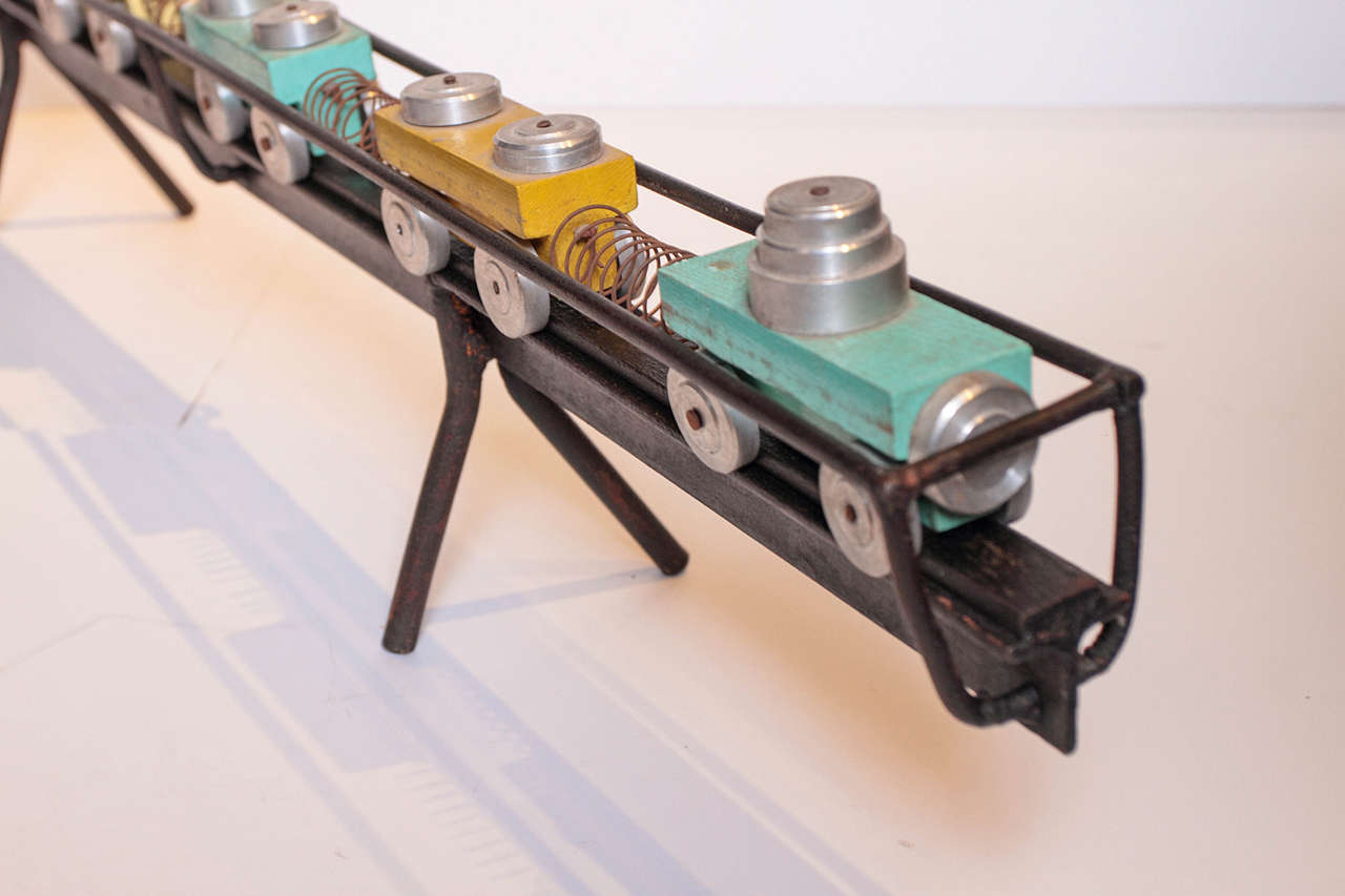 Decorative, hand-painted French train toy set as collectible accessory piece. 
Original patina of wooden blocks with characteristic features of chrome metal tops and wheels, and metal springs that connect each cart. 

Vintage accessory is placed on