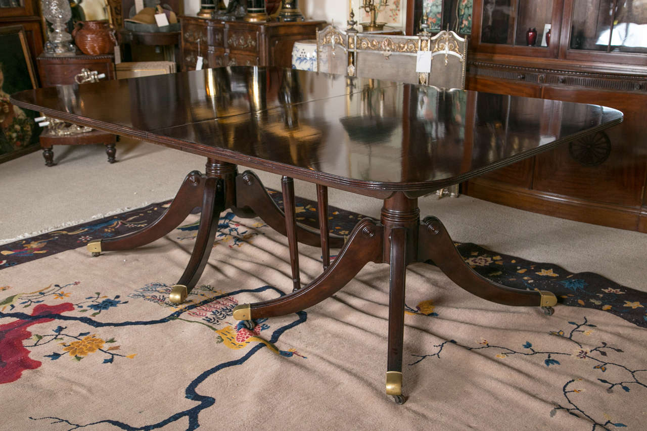 A two-pedestal, mahogany banquet table by Baker having two original leaves measuring 36" wide each and a later added leaf measuring 18" wide. The table measures 152.5" when fully extended and 80.5" when fully closed.  The