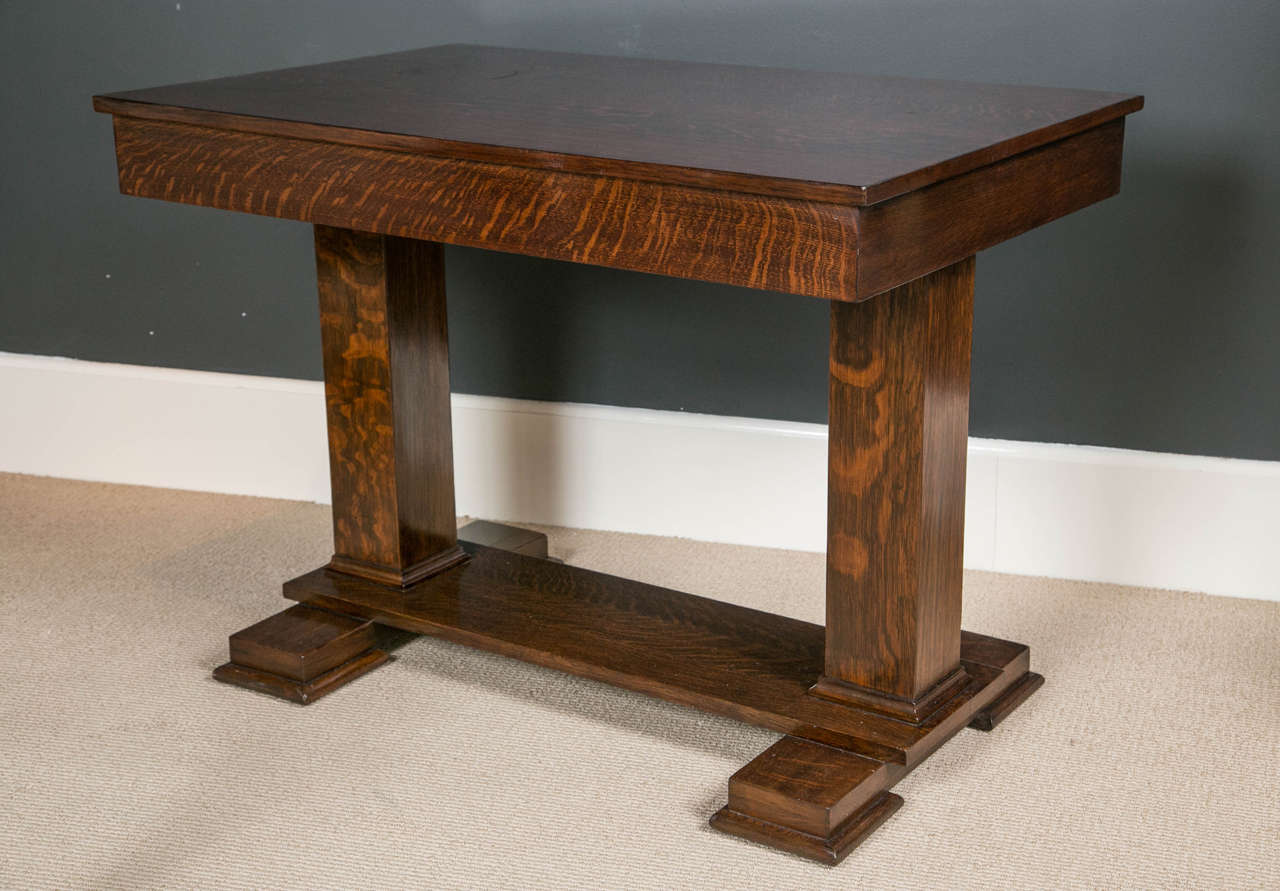 An early 20th Century American quarter-sawn, oak table with single drawer over a trestle form base.