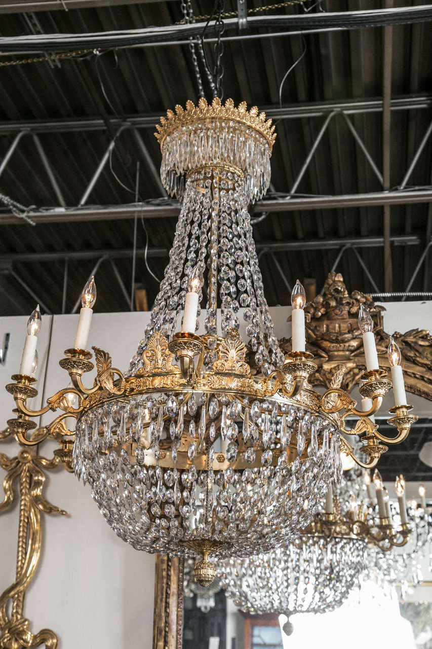 An exquisite, 12-light, doré bronze and crystal Empire style Continental chandelier.