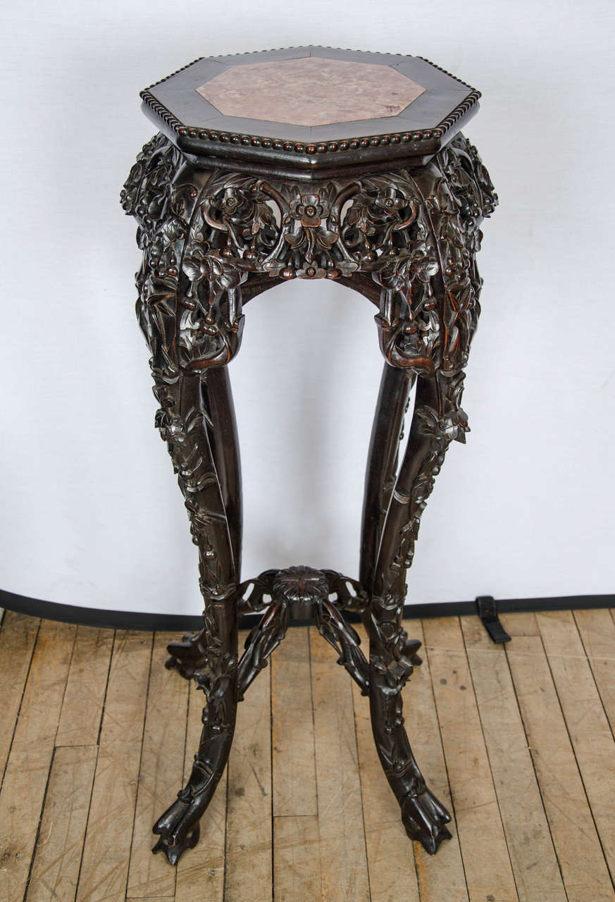 This well-proportioned and beautifully carved 19th century padouk jardiniere features a marble center inset a hexagonal shaped top. The Jardiniere is supported on four heavily carved cabriole legs with a cross frame stretcher base. It measures 15 ½