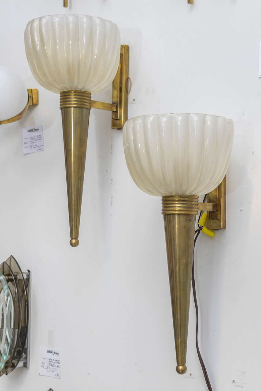 Pair of torch style Murano glass sconces with conical brass armature and fluted glass shades.