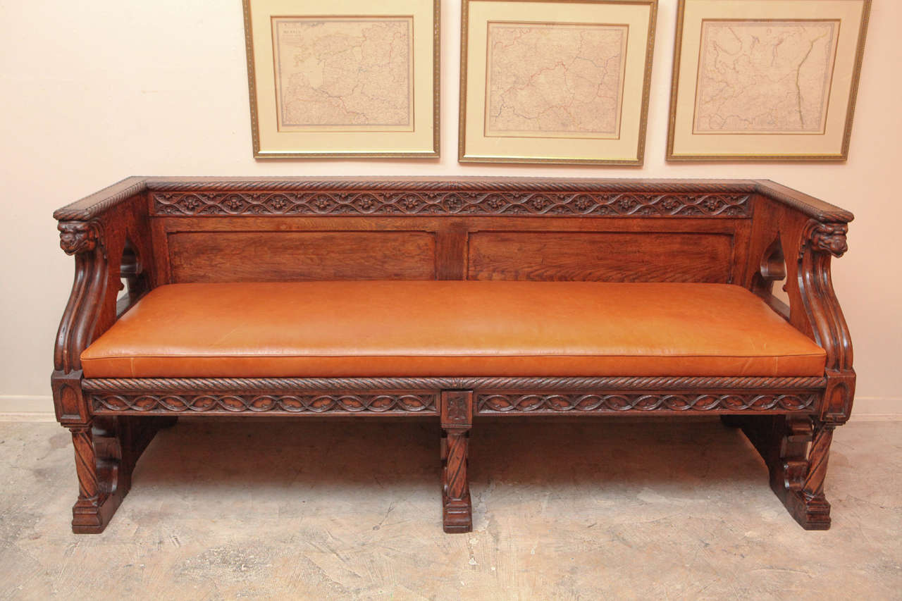 19th century English oak Gothic style leather bench. The leather upholstered bench is finished on the back and can be floated in the center of a room.