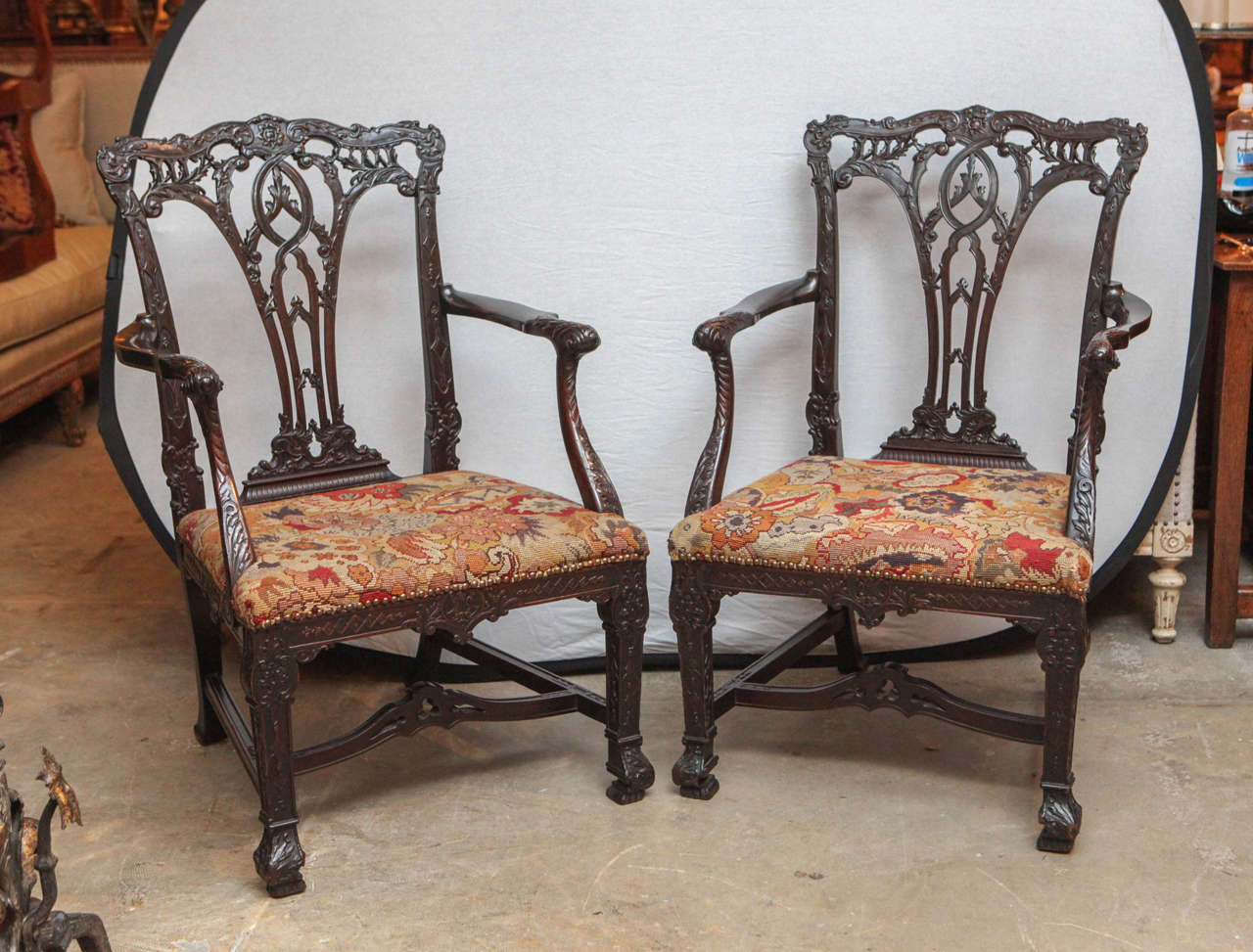 Pair of 19th century English very finely carved mahogany oversized open armchairs with original needlepoint seats.