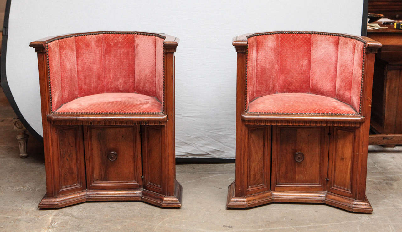 19th century pair of Italian walnut barrel chairs with single door beneath each chair.