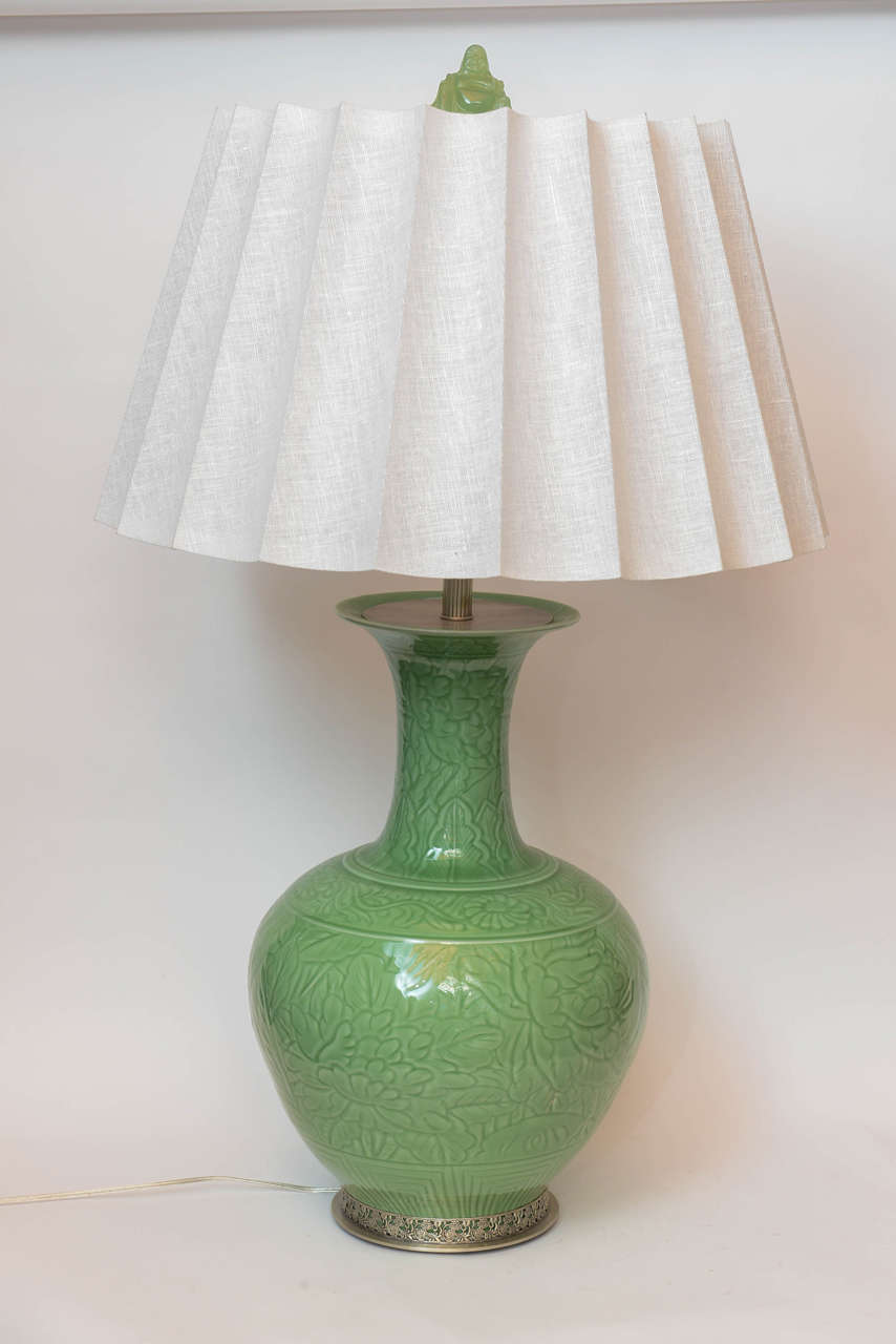 A pair of Chinese porcelain leafy motif engraved green jade colored lamps.