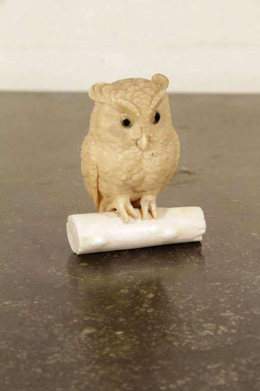 This Japanese Meiji period okimono figure of an owl perched on a log is finely carved from ivory with eyes made of horn inlaid mother of pearl. Such decorative objects became increasingly popular during the late nineteenth century, and were exported