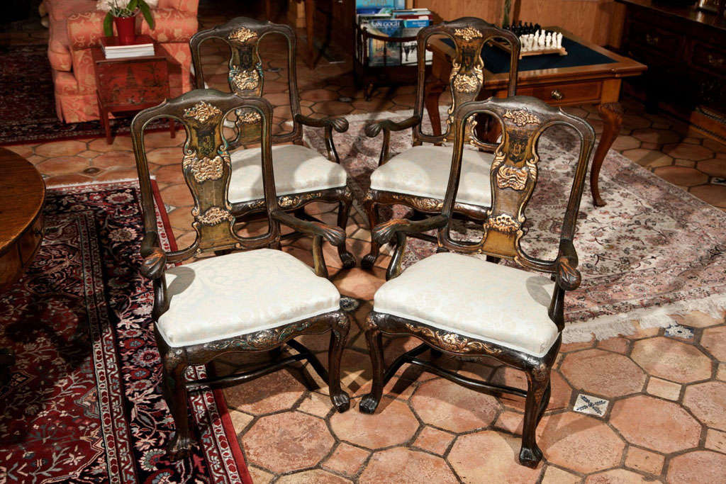 This unique and rare set of four Portuguese painted arm chairs in original finish with parcel gilt accents features two subtly different coats of arms. While all four chairs display a ducal coat of arms with a crown over the green framed shield, one
