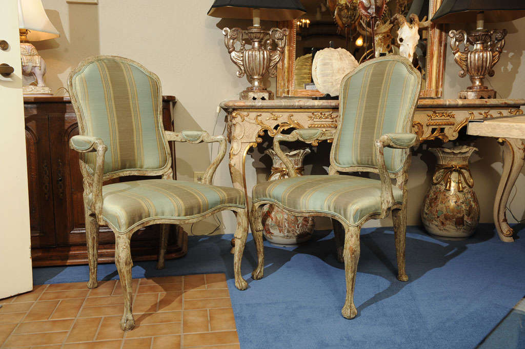 Each upholstered back flanked by undulated padded arms over a fitted seat above a scalloped apron raised on cabriole legs ending on claw and ball feet.  Upholstery in pale hued stripe with nubby back.  Exquisite patination.