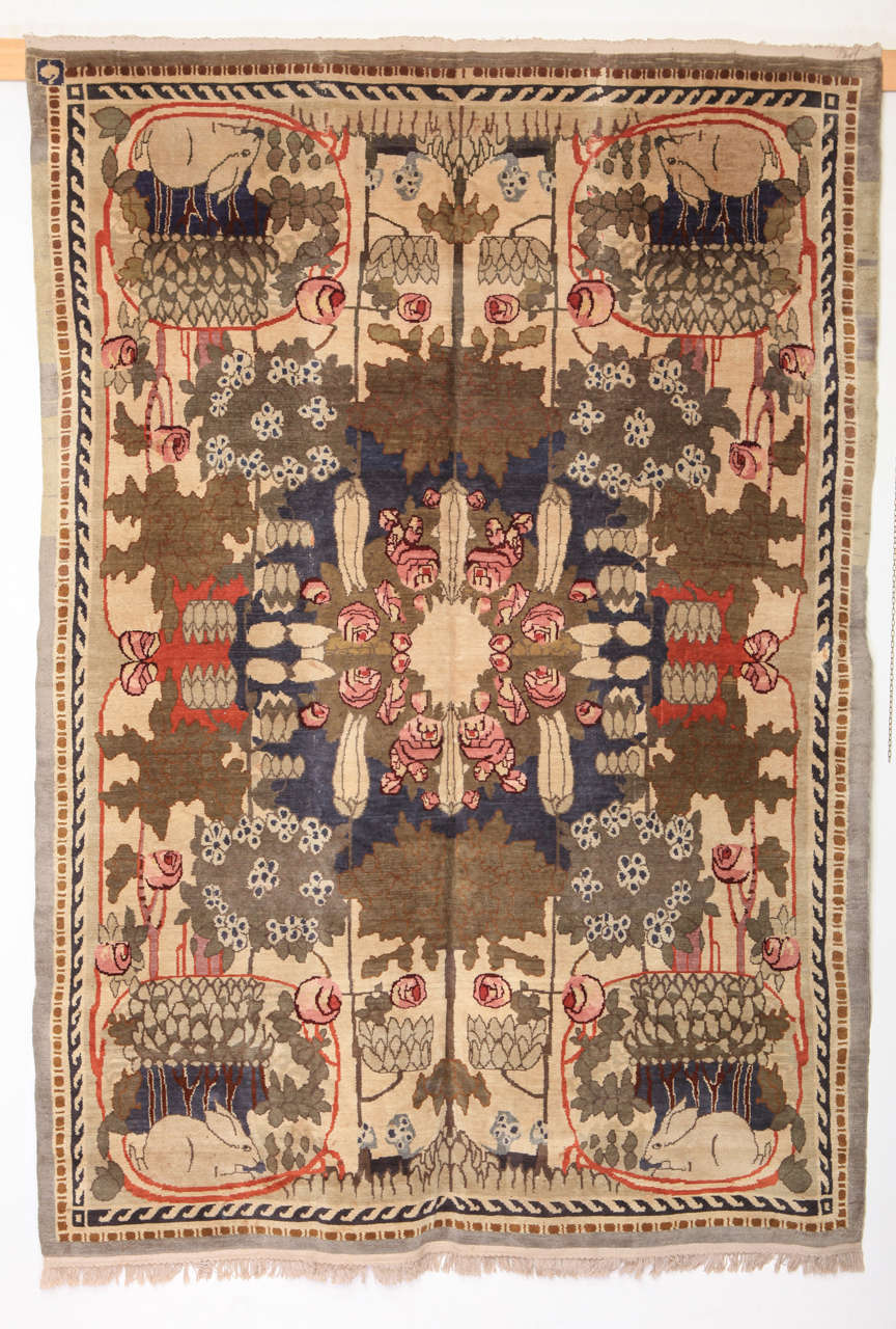 A rare and unusual European Art Deco carpet, distinguished by a pattern of stylized floral bouquets forming a centralized design with four rabbits placed in every corner. It also carries a woven monogram consisting of a bird-like figure which we