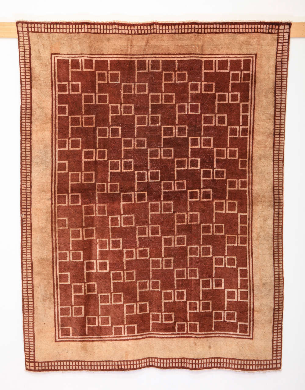 A rare and unusual carpet woven in two colors with an all-over pattern of square devices. Although it was originally sourced in China, carpets of this type were influenced by the European design movements of the 20th century.