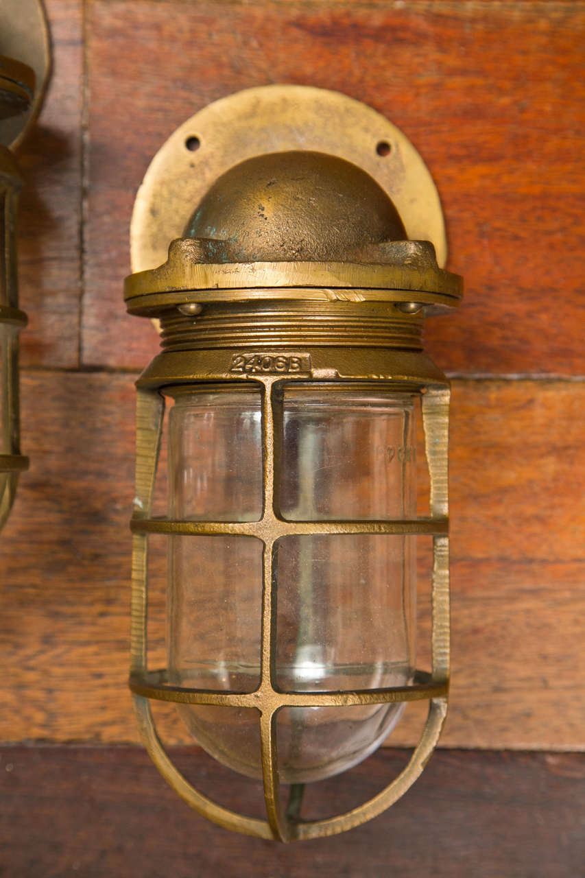 1950 heavy cast bronze passage lamps with side wall mount. Glass cover over bulb. Sold in pairs- Only 3 pairs available- Priced per pair.  Lamp is marked 