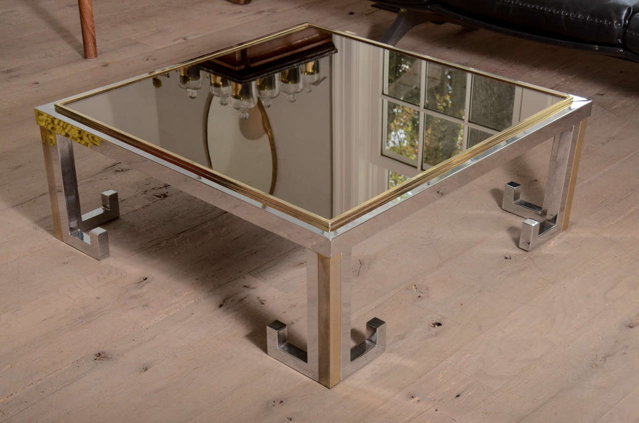 Beautiful 1960s glass table with chrome and brass Greek key design and smoked glass top.